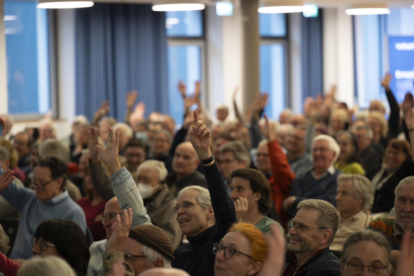 Publikum meldet sich mit erhobenen Händen beim Wärmepumpen-Infotag in Freiburg. Foto: Stadt Freiburg