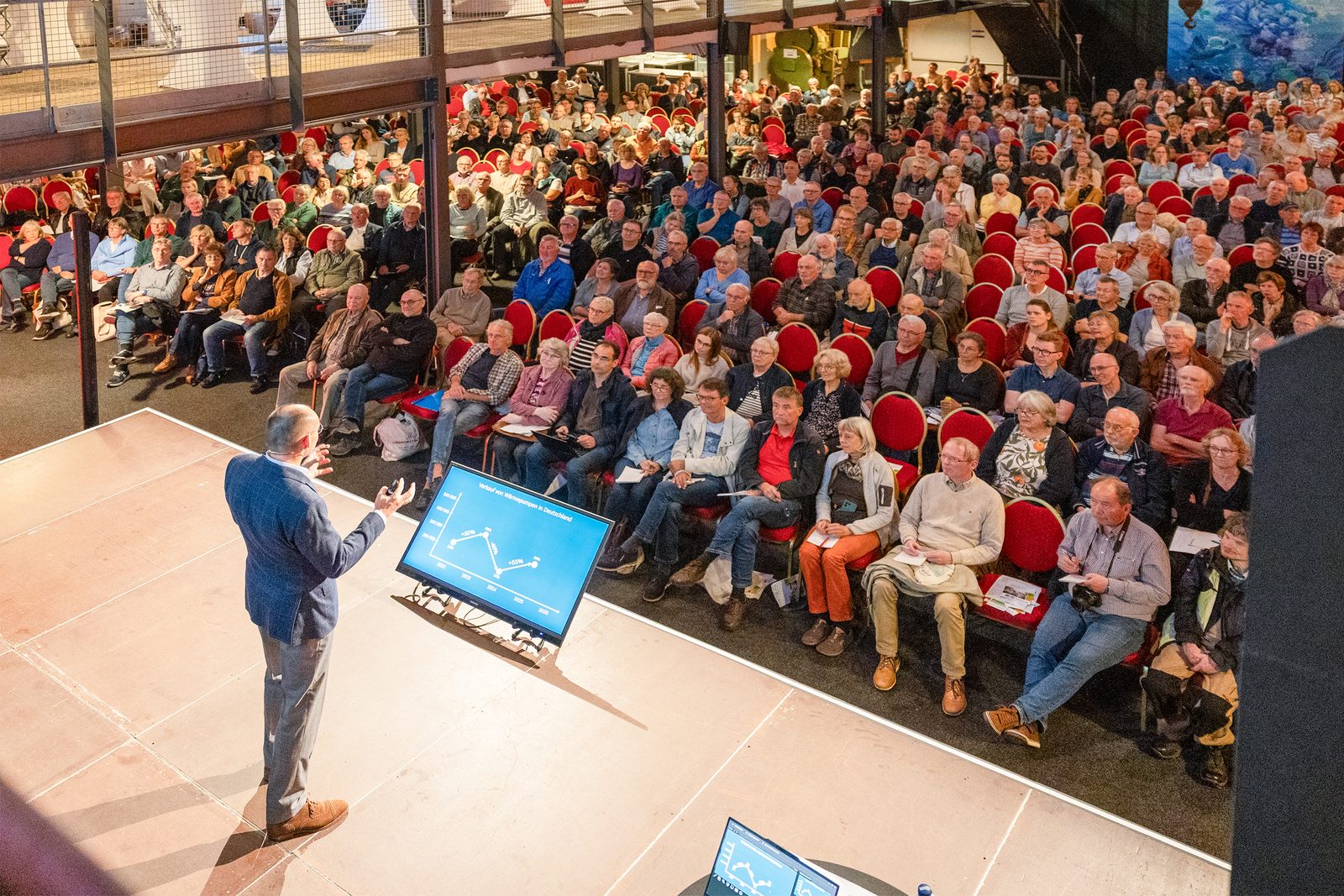 Dr. Marek Miara auf der Bühne vor dem vollen Saal