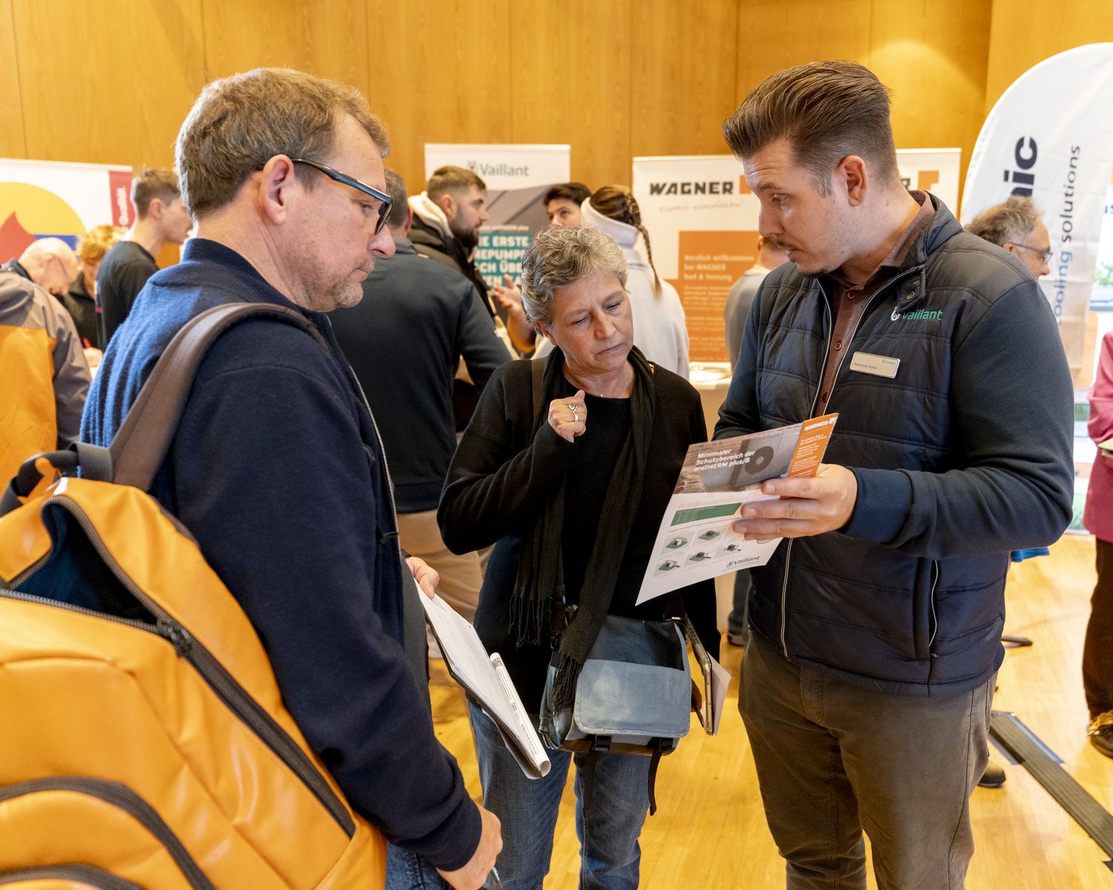 Besucher mit Unterlagen im Gespräch mit einem Berater