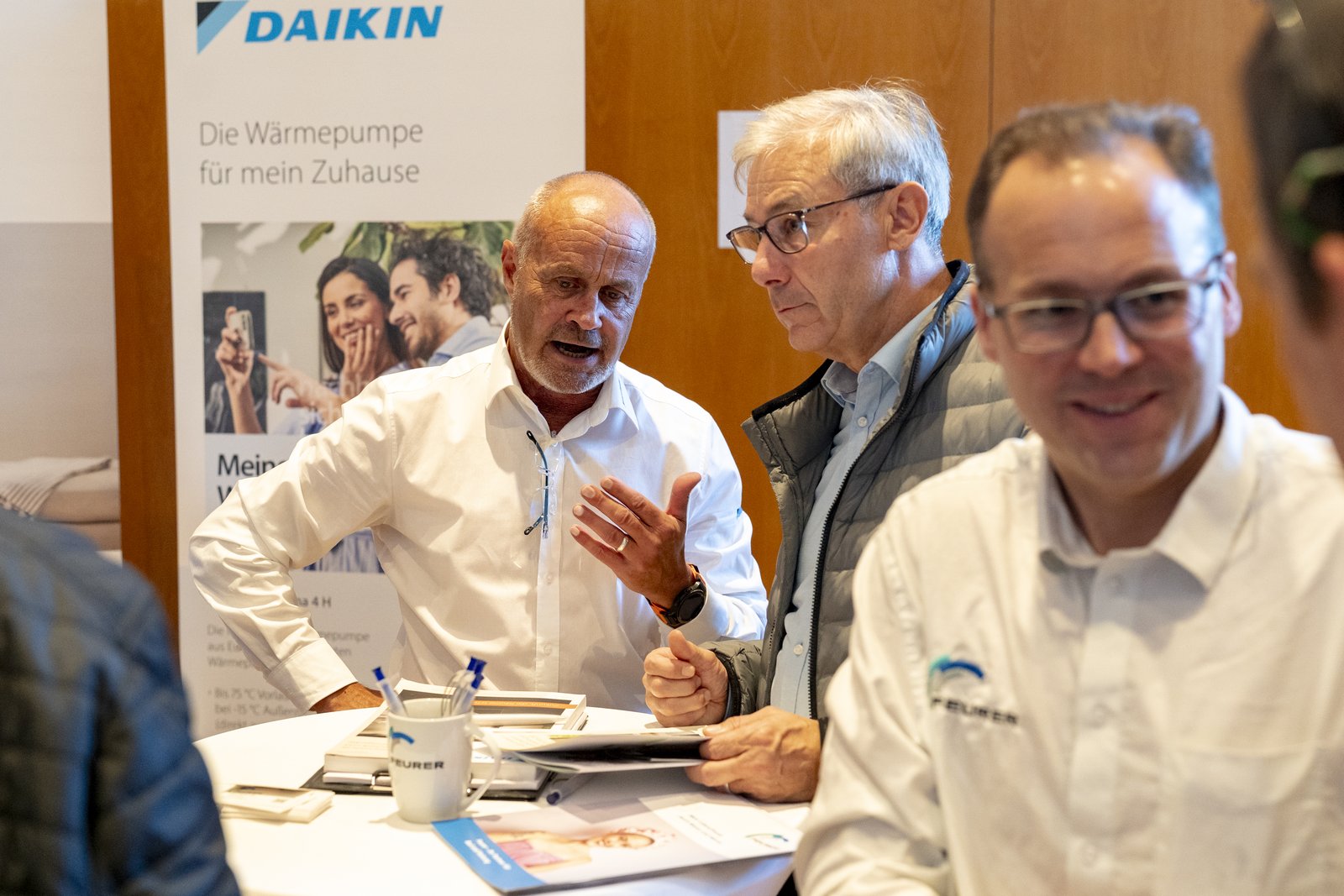 Fachleute im Gespräch mit Besuchern am Stehtisch