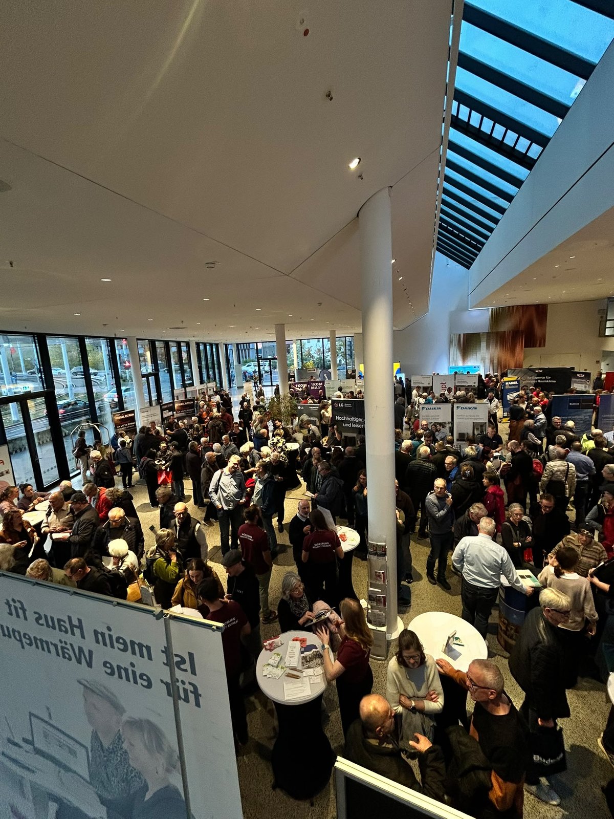 Volles Foyer unter dem Glasdach, Gäste an den Stehtischen