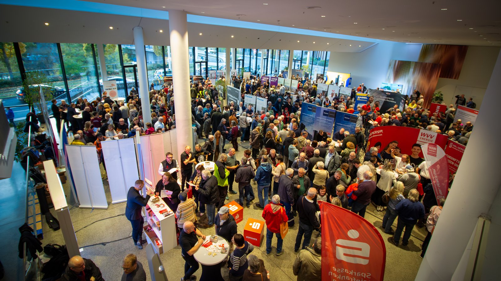 Volles Foyer mit Ständen rundum