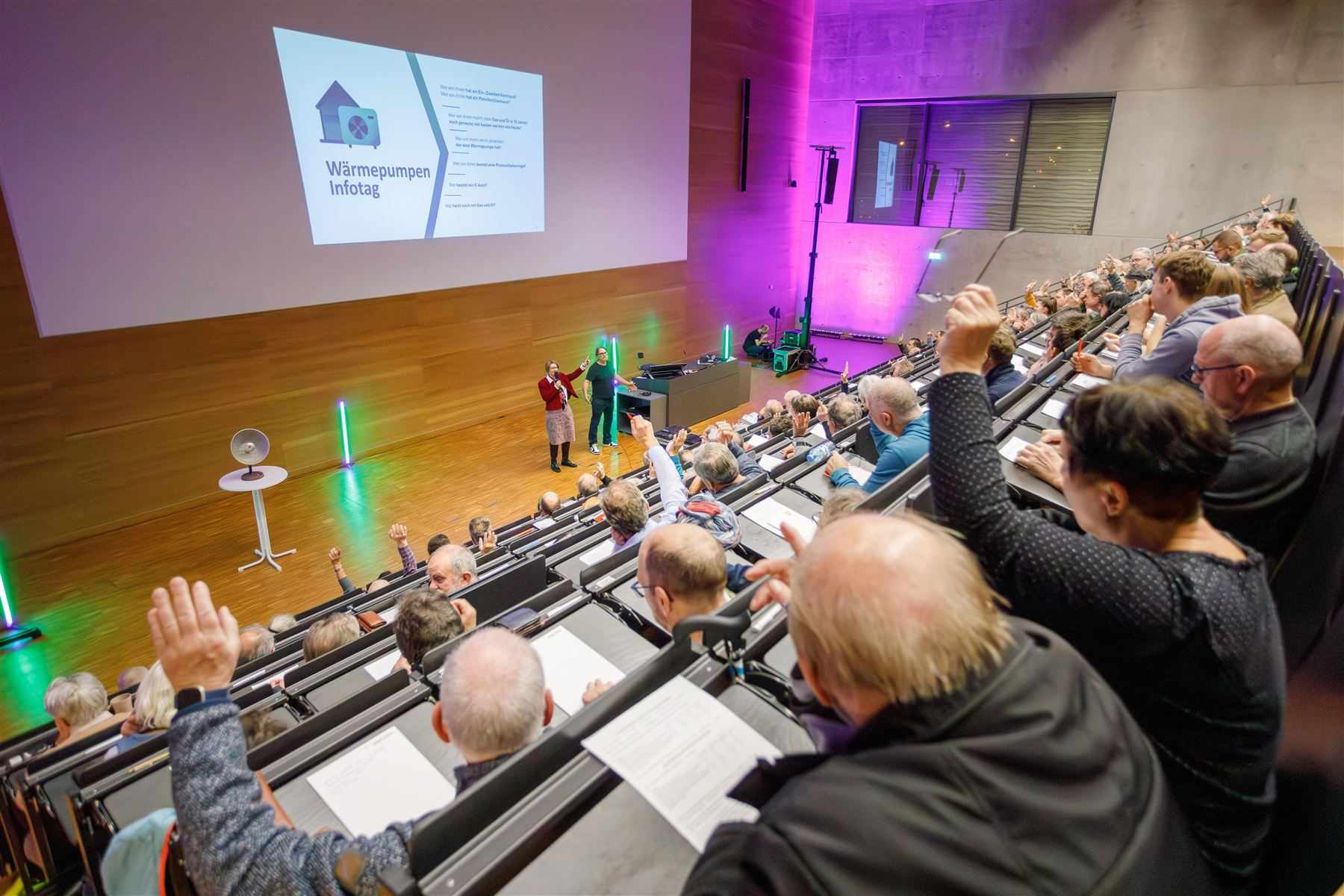 Hörsaal in Erfurt mit erhobenen Händen beim Wärmepumpen-Infotag