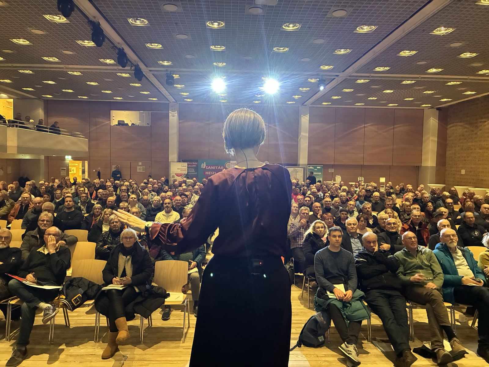 Anja Floetenmeyer-Woltmann spricht vor vollem Saal in Neumünster